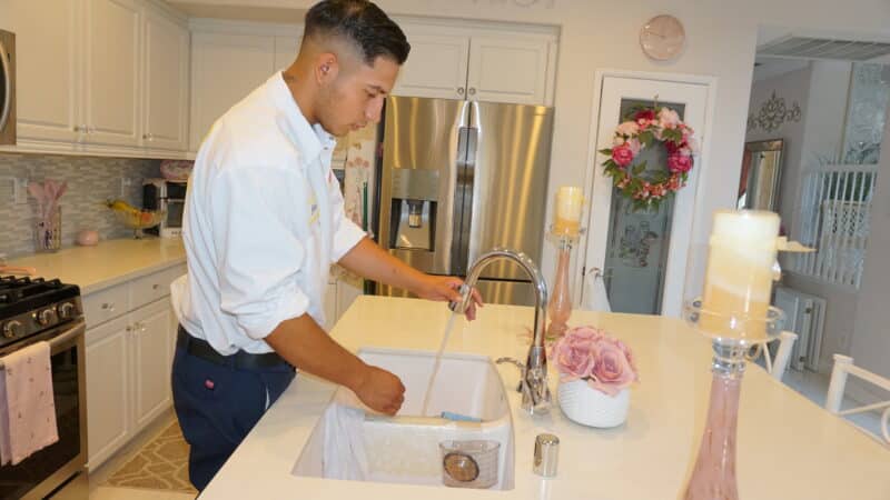 HomeX plumber checking kitchen sink water pressure